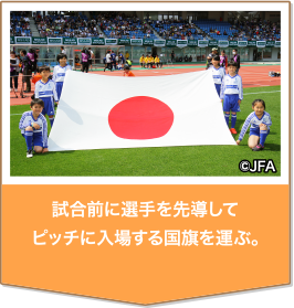 試合前に選手を先導してピッチに入場する国旗を運ぶ。