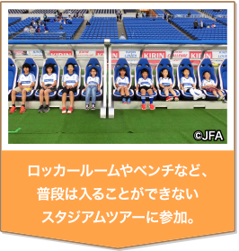 日本の国旗を携えて、サッカー日本代表選手をピッチに誘導。